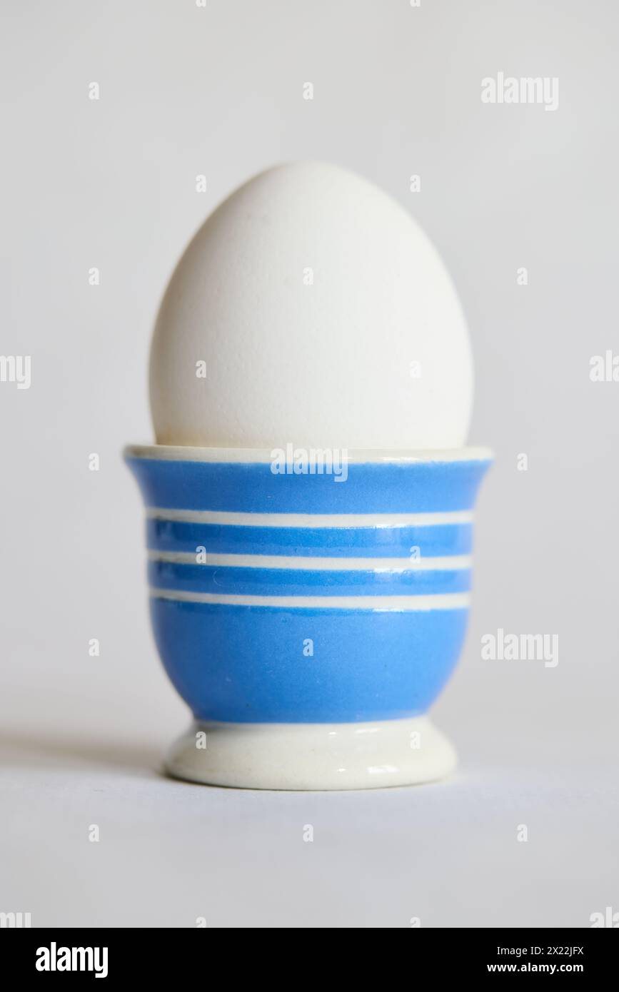 White egg in a blue and white ceramic egg cup Stock Photo