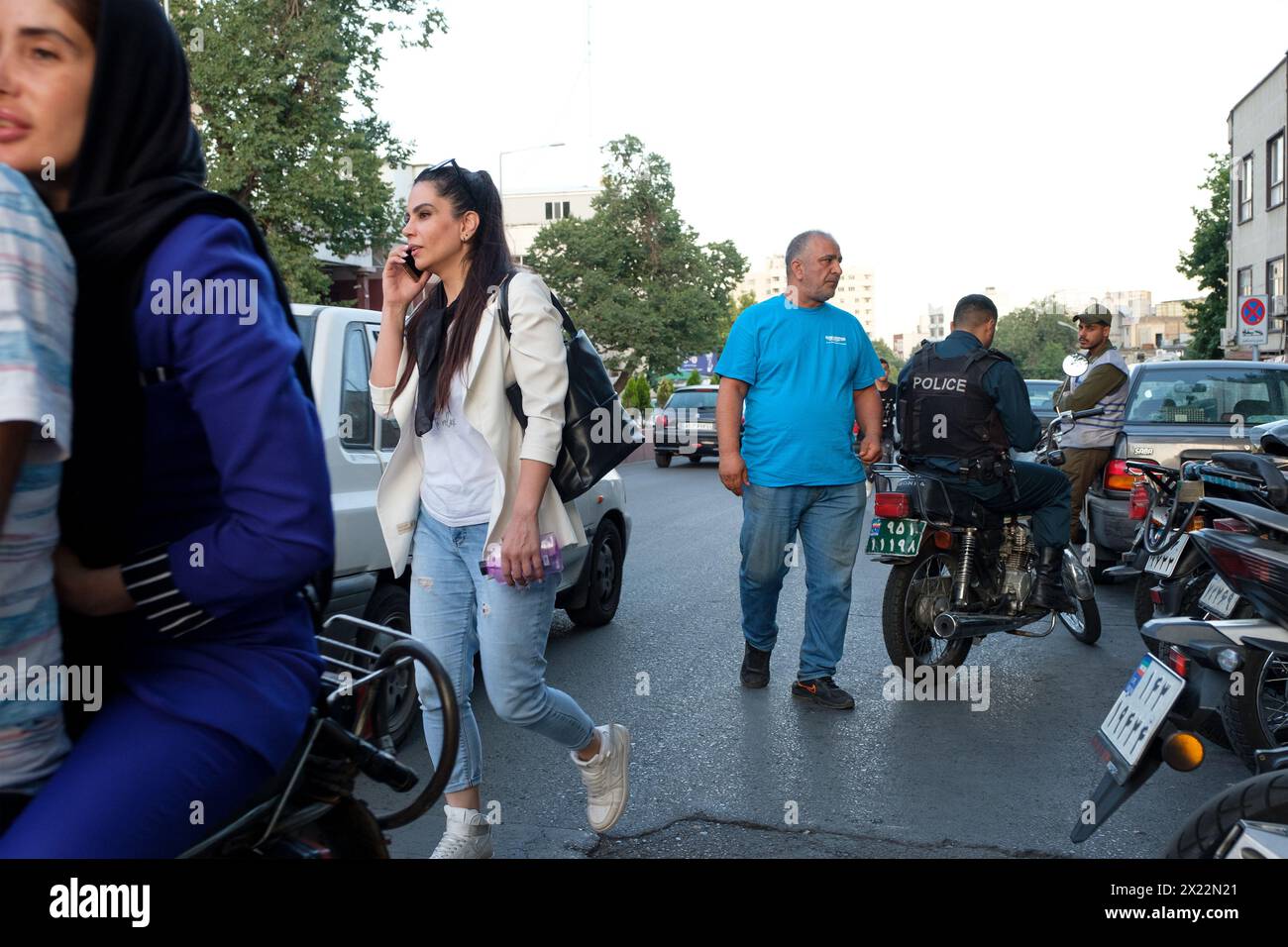 An Iranian Girl in Tehran resisting compulsory hijab by walking without scarfs in public. Stock Photo