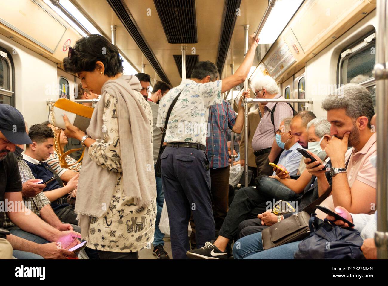 Iranian Girl on a subway train in Tehran resisting compulsory hijab by showing her hair in public. Stock Photo