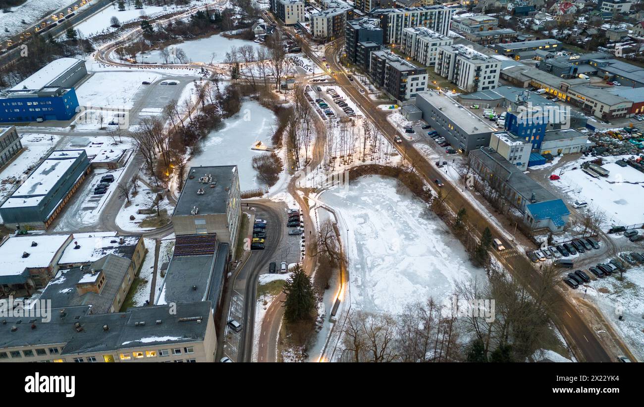 Drone photography of frozen up pond between houses and streets during winter cloudy morning Stock Photo