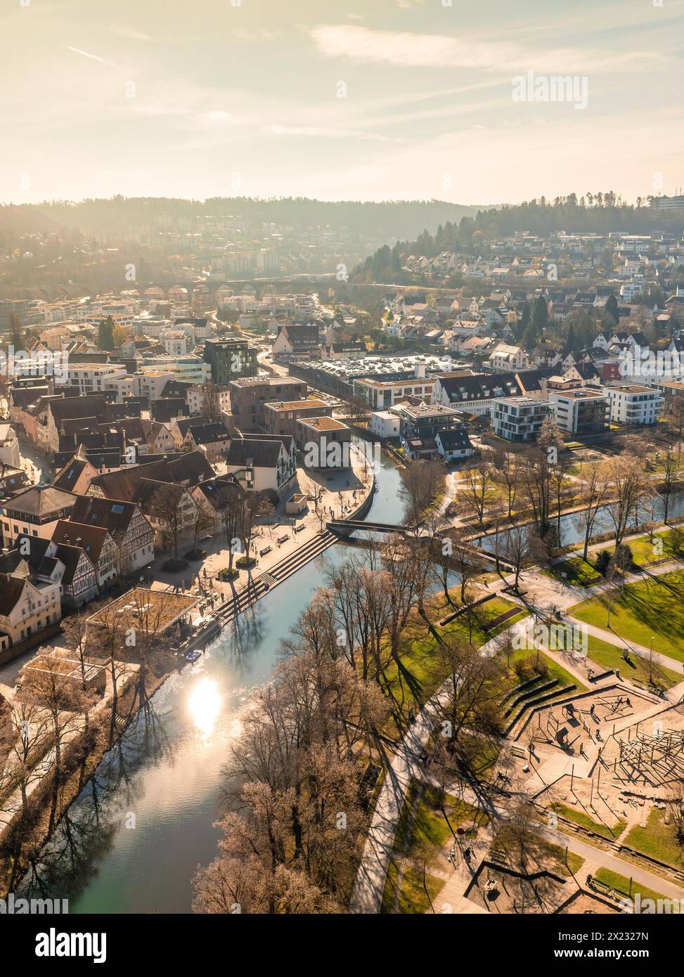 Aerial view of a city panorama with river and sun reflections next to urban architecture, sunrise, Nagold, Black Forest, Germany Stock Photo