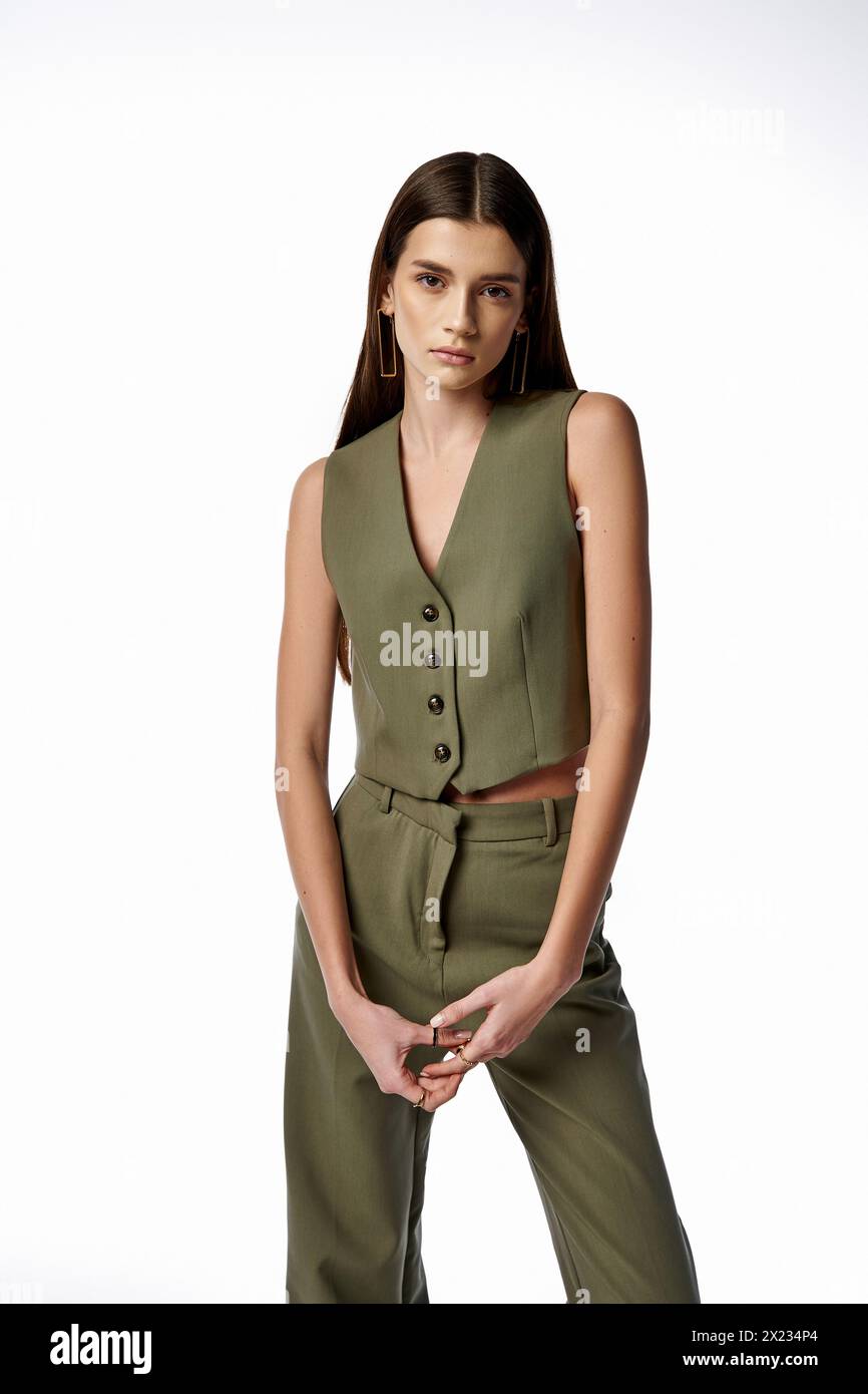 A fashionable woman with long dark hair striking a pose in a green suit ...