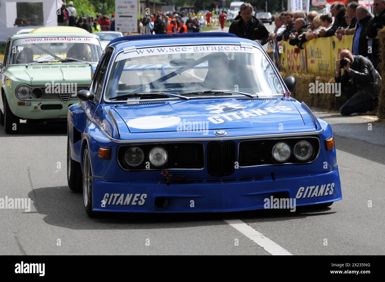 A blue BMW racing car with Gitanes branding at a road race, surrounded by spectators, SOLITUDE REVIVAL 2011, Stuttgart, Baden-Wuerttemberg, Germany Stock Photo