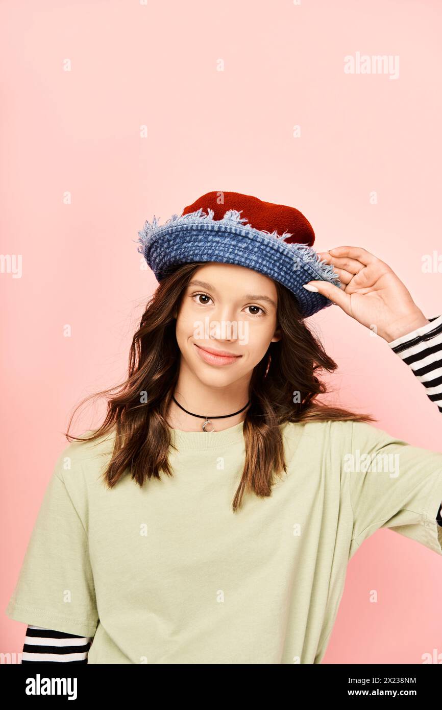 A stylish teenage girl in a striped shirt and hat poses confidently in ...