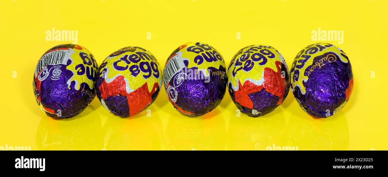 Five Cadbury Creme Eggs in a row on Yellow Background, Easter Eggs. Panoramic image Stock Photo