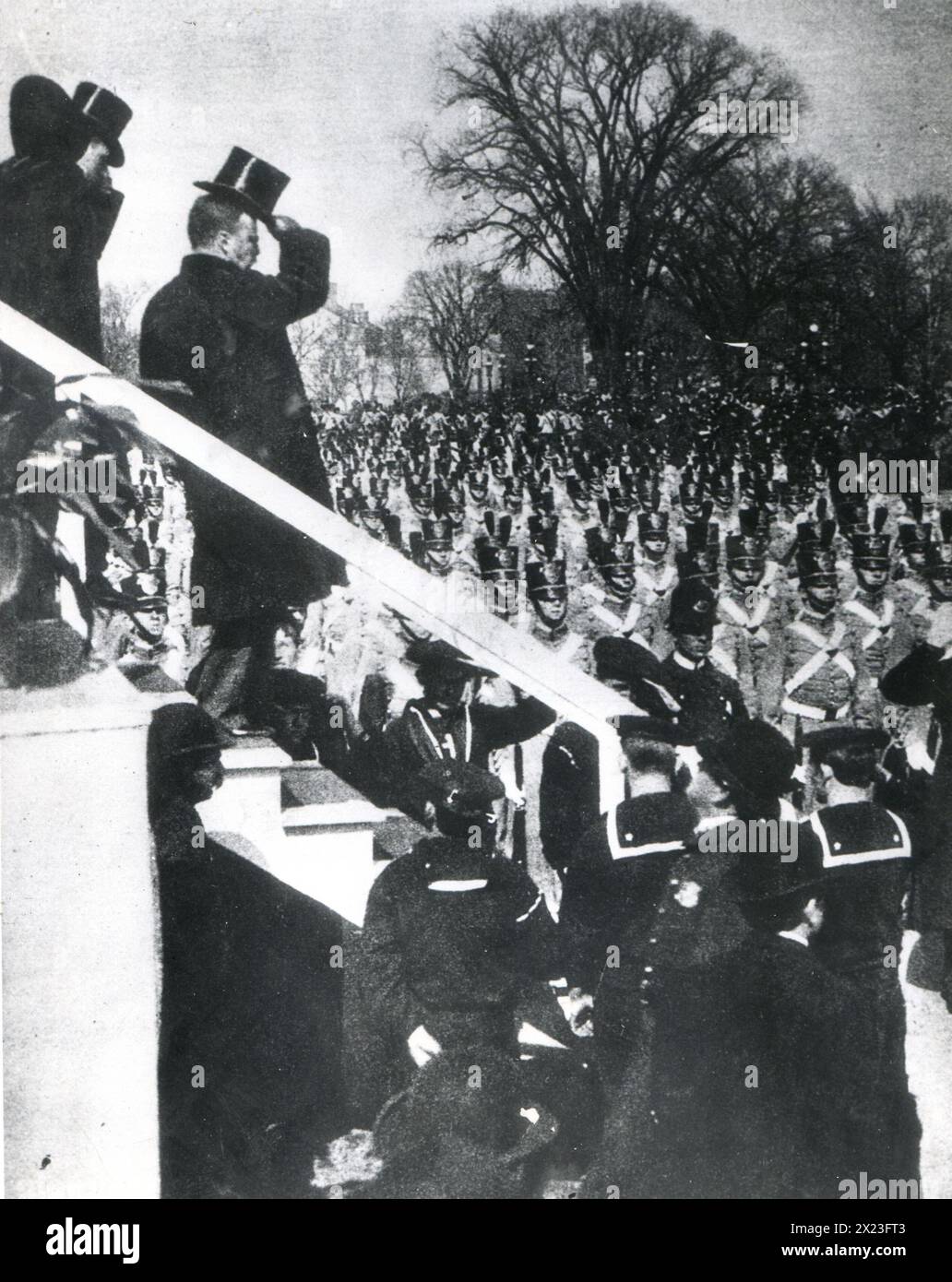 1904 - President Theodore Roosevelt shown tipping his hat to a troop of West Point cadets passing the reviewing stand during Roosevelt's Inaugural Parade. Stock Photo