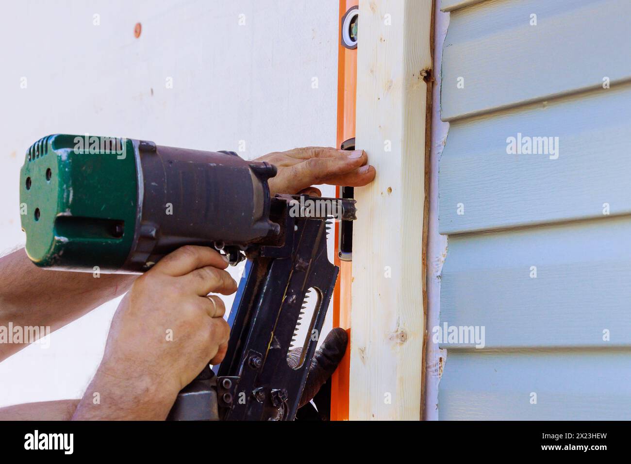 Worker Installing Beams Using An Air Hammer In Wooden Frame Stock Photo