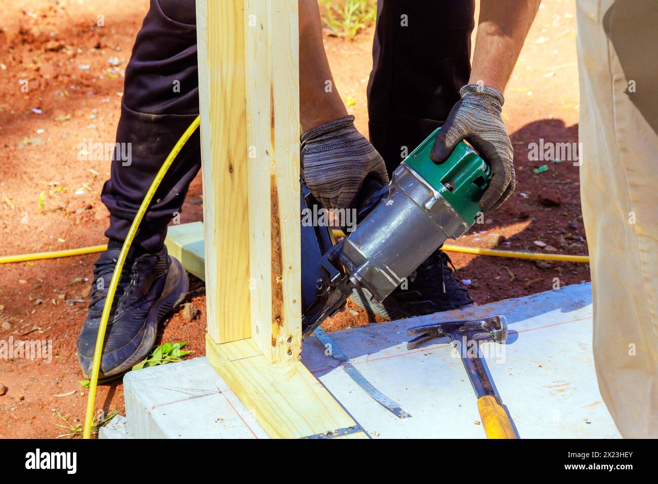 Framer uses an air nail hammer to install beams in wooden frame Stock ...