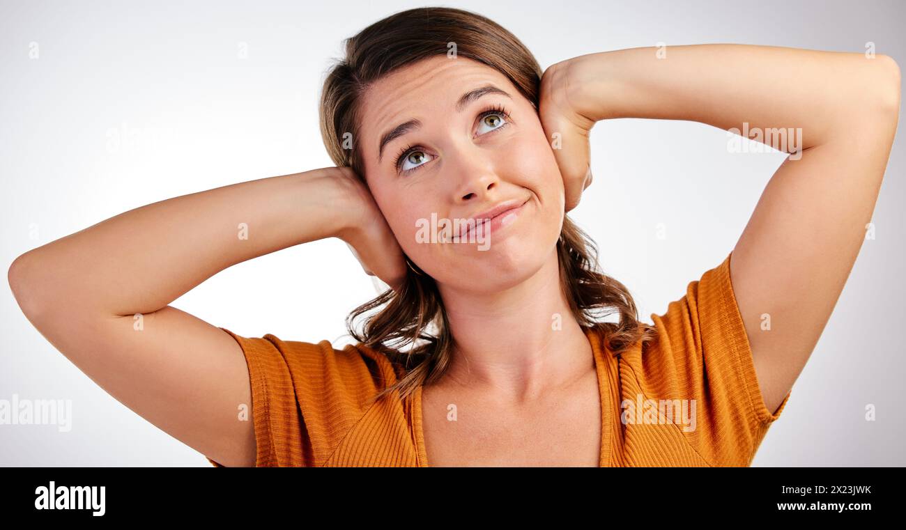 Hands on ears, noise and woman in studio with fake news block, secret or annoyed with gossip drama on white background. No, stop and girl model with Stock Photo