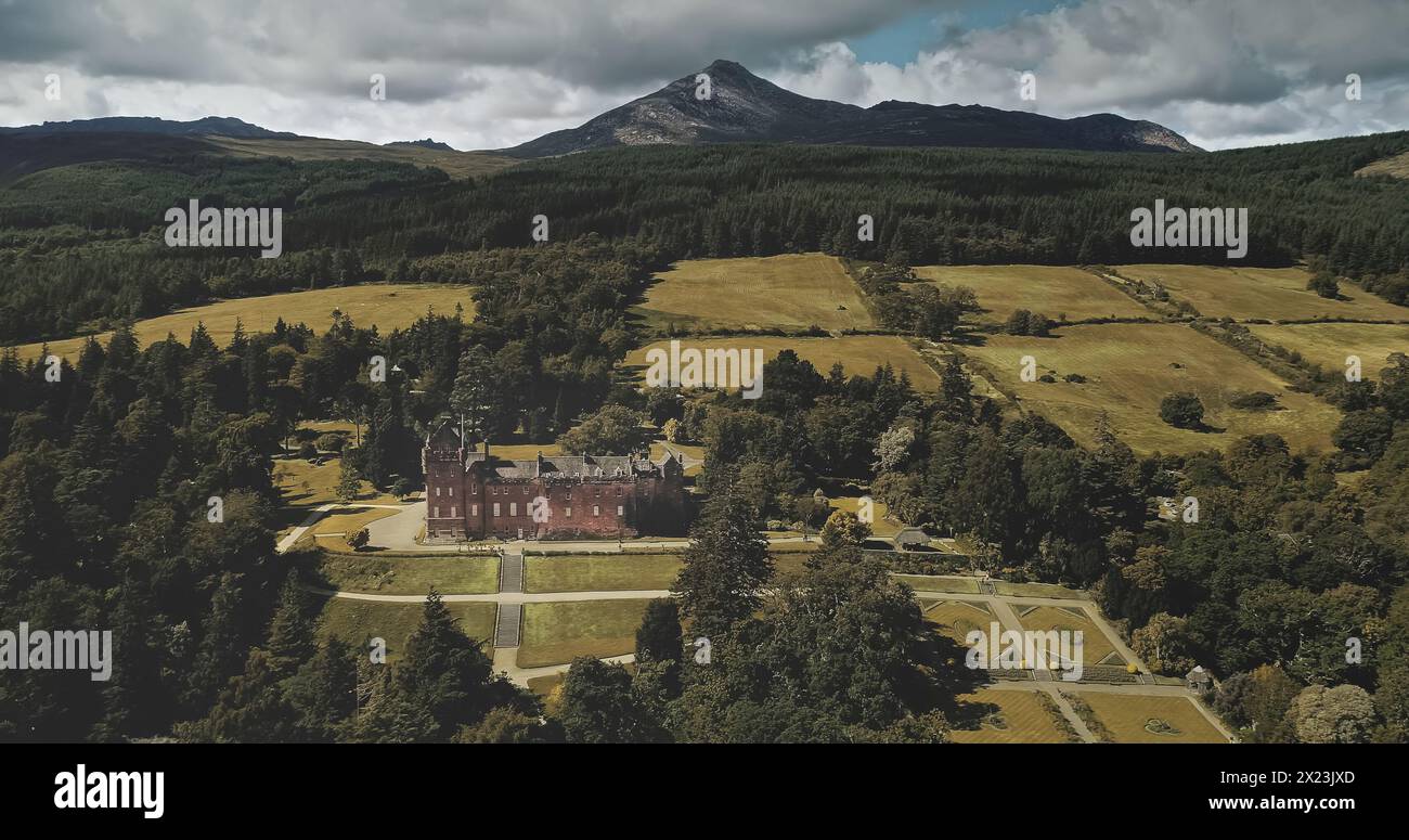 Scotland landscape aerial shot: mountains, ancient Brodick Castle with Goatfell mount. Epic scenery of Scottish landmarks. Wonderful forests and valleys at summer day wide view Stock Photo