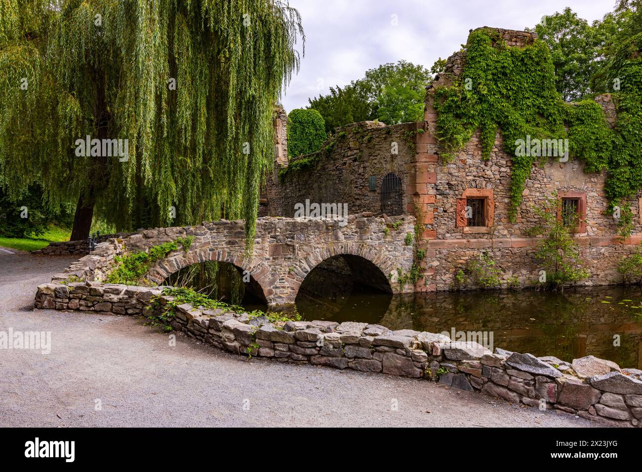 Dreamy ruins with a historical ambience in the picturesque Schöntal city park under old trees, ancient arches and cloudy skies Stock Photo