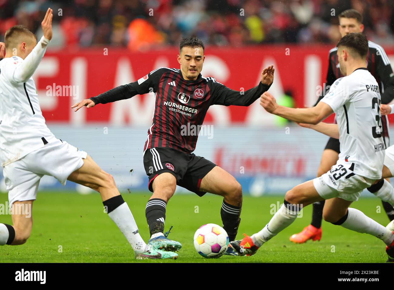 Nuremberg, Germany. 19th Apr, 2024. Soccer: Bundesliga 2, 1. FC Nürnberg - SC Paderborn 07, matchday 30 at the Max Morlock Stadium. Nuremberg's Jens Castrop (center) battles for the ball with Filip Bilbija (left) and Marcel Hoffmeier from Paderborn. Credit: Daniel Karmann/dpa - IMPORTANT NOTE: In accordance with the regulations of the DFL German Football League and the DFB German Football Association, it is prohibited to utilize or have utilized photographs taken in the stadium and/or of the match in the form of sequential images and/or video-like photo series./dpa/Alamy Live News Stock Photo