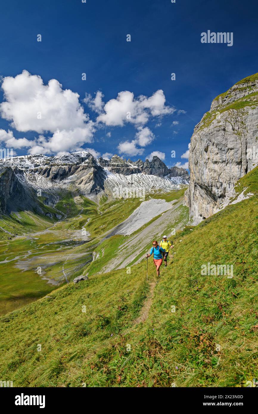 Man and woman hiking with a view of Tschingelhörner and Lower Segnesboden, Tectonic Arena Sardona, Glarus Main Thrust, UNESCO World Natural Heritage G Stock Photo