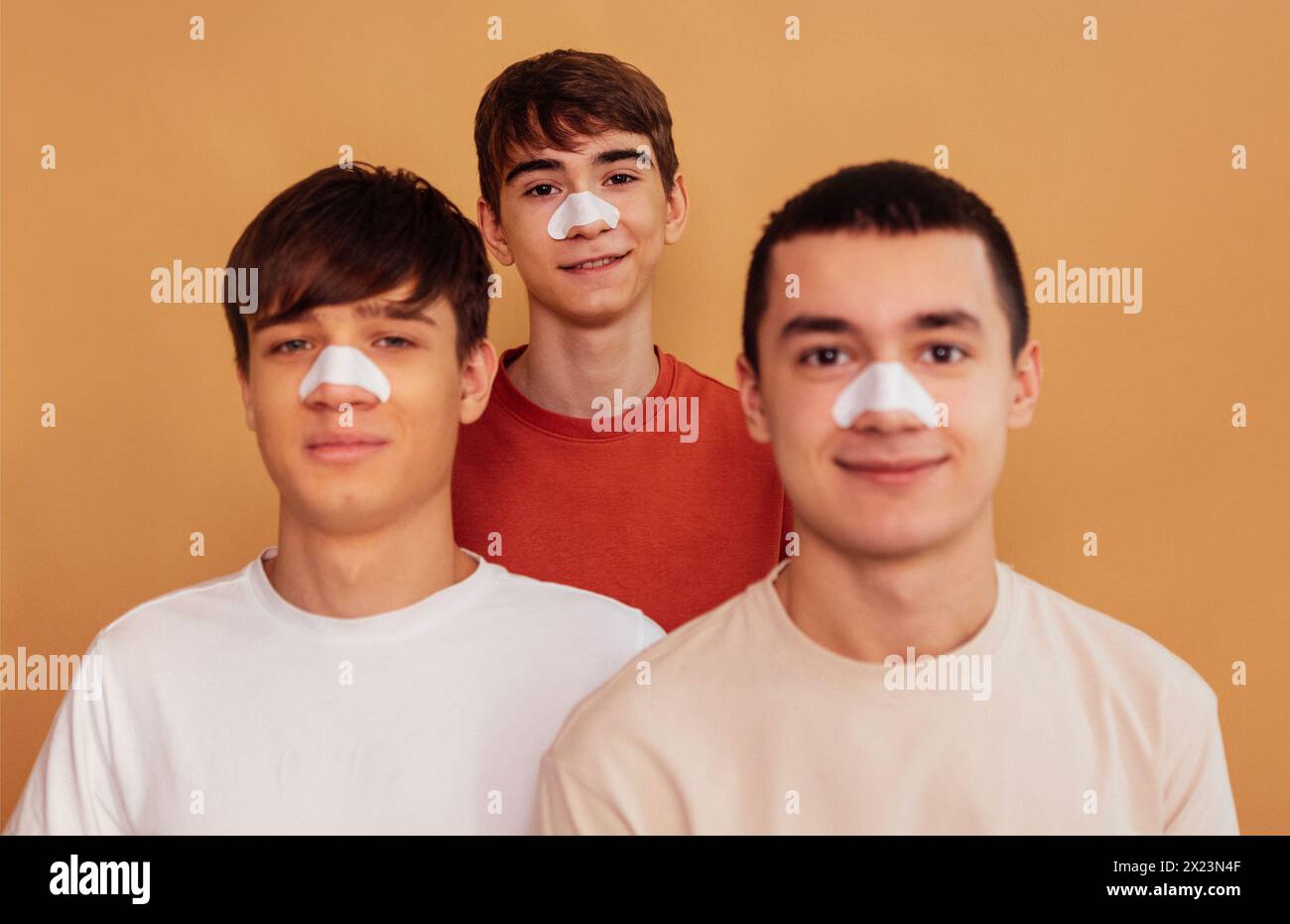 Portrait of teenagers with cleansing strips on their noses to remove
