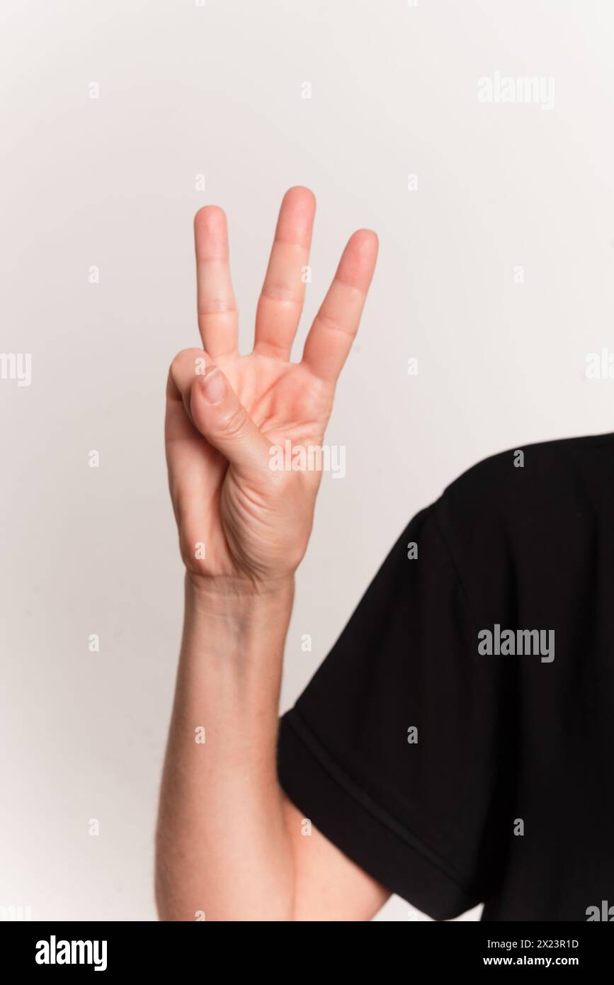 Close up of a hand making the letter w in the sign language for the