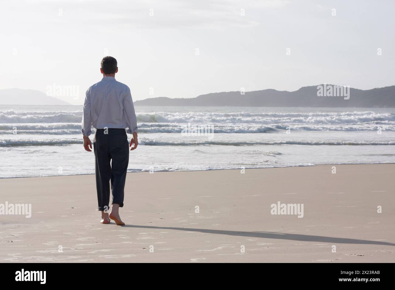 Businessman walks barefoot on the beach, Bombinhas, Santa Catarina, Brazil Stock Photo