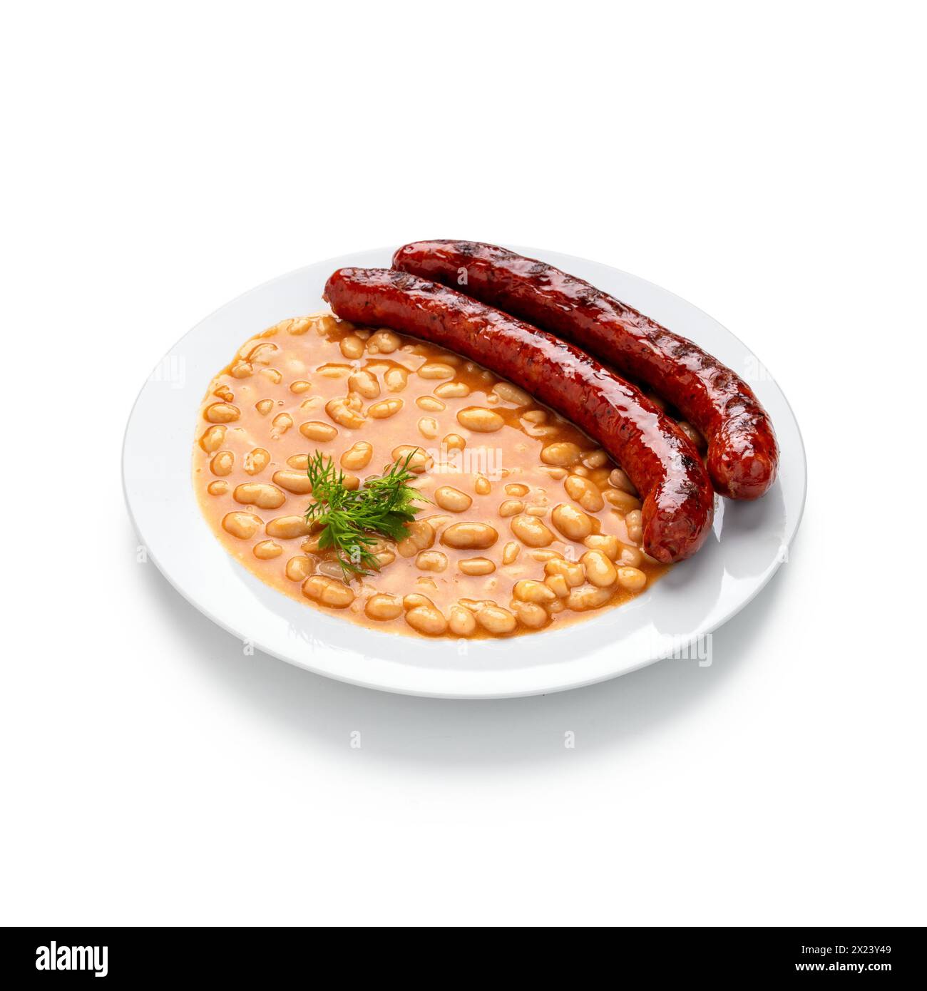 Indulge in the rustic charm of a hearty bean stew with succulent sausages, served elegantly on a pristine white plate. This comforting dish brings war Stock Photo