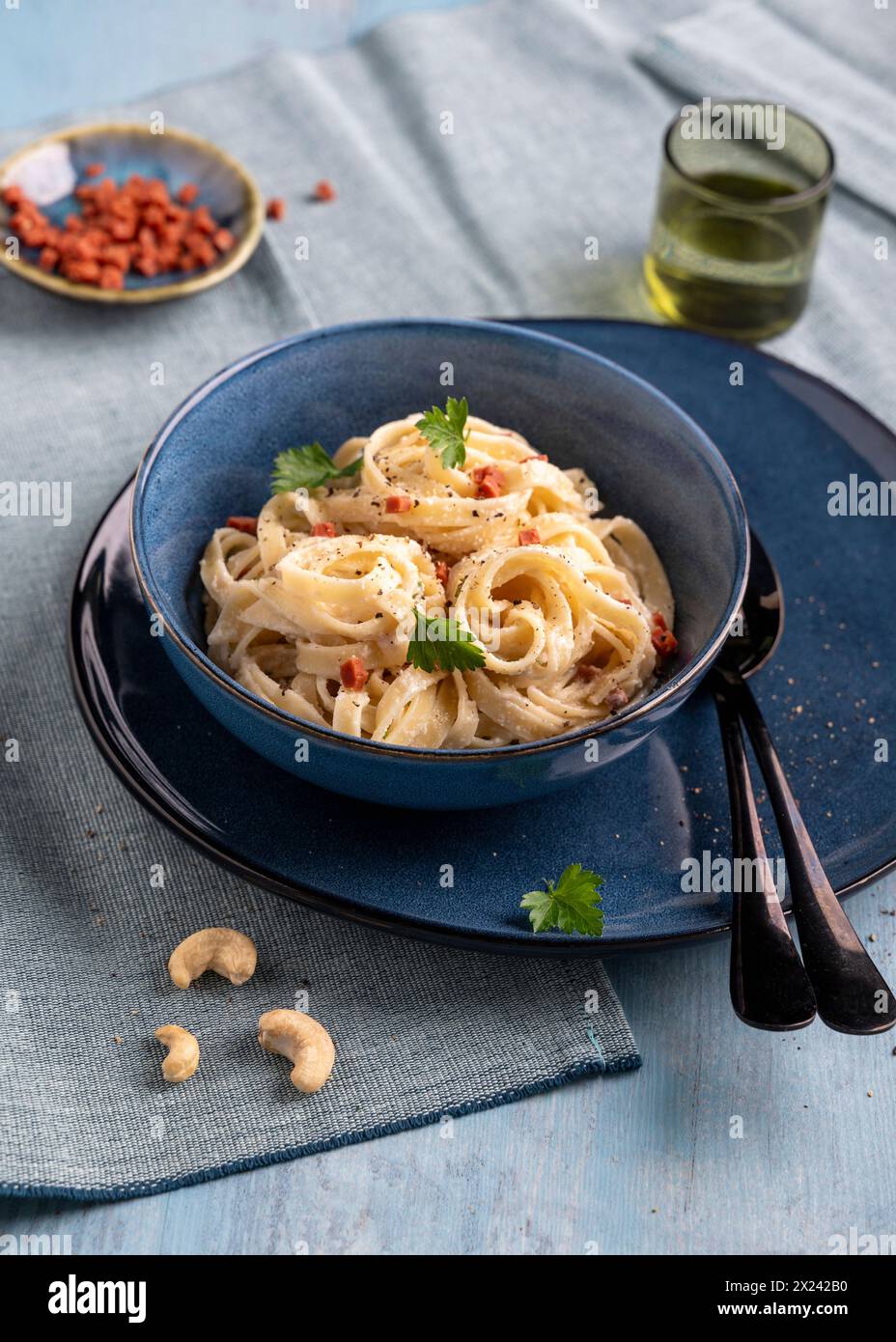 Vegan pasta carbonara with cashew cream and ham substitute Stock Photo