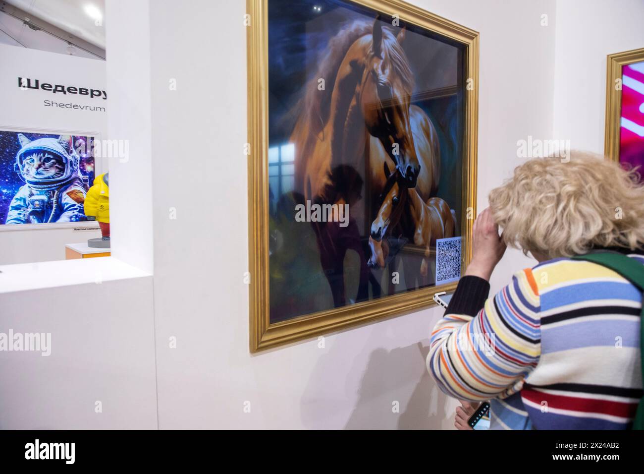 Moscow, Russia. 19th of April, 2024. Visitors to an exhibition watch paintings generated by the Shedevrum AI app of Yandex IT company, on the territory of the Yandex stand at the VDNKh exhibition complex in Moscow, Russia Stock Photo