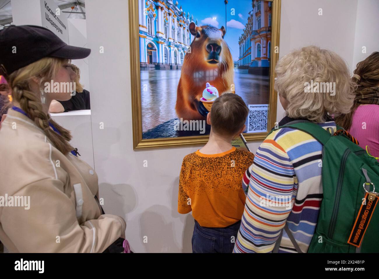 Moscow, Russia. 19th of April, 2024. Visitors to an exhibition write prompts for generation of paintings by the Shedevrum AI app that generates ‘artwork’, on the territory of the Yandex stand at the VDNKh exhibition complex in Moscow, Russia Stock Photo
