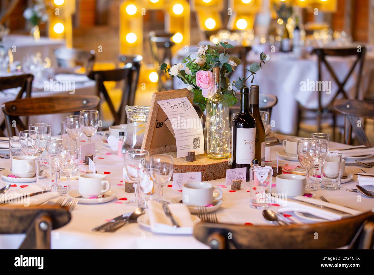 Wedding centrepiece featuring 'I Spy' game, artificial flowers, wine and LED lights in a bottle Stock Photo