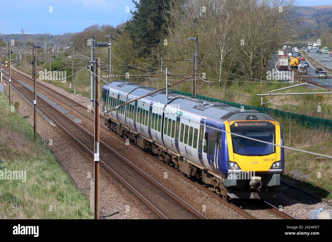 Northern trains class 195 Civity diesel multiple unit heads south on West Coast Main Line in Lancashire on 19th April 2024 alongside M6 motorway. Stock Photo