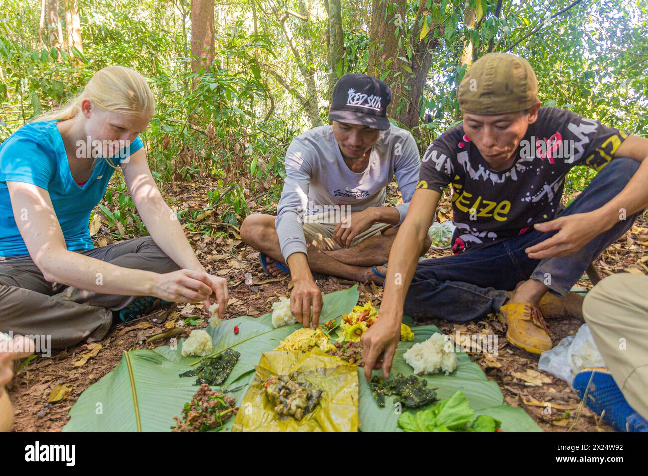 NAM HA, LAOS - NOVEMBER 15, 2019: Local guides and tourists eating in the forest of Nam Ha National Protected Area, Laos Stock Photo