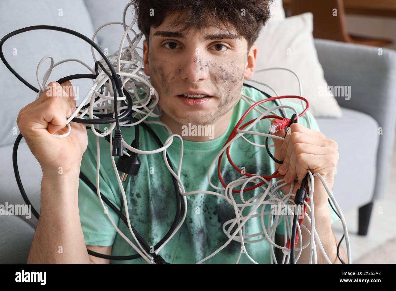 Electrocuted young man with burn face and wires at home, closeup Stock