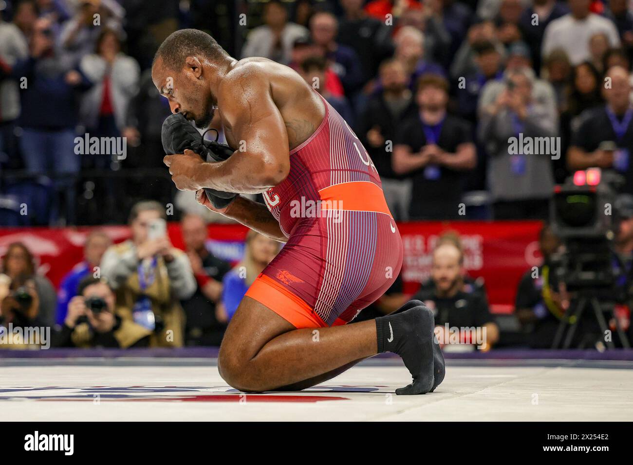 State College, Pennsylvania, USA. 19th Apr, 2024. J'DEN COX (red singlet) kisses his shoes prior to leaving them in the center of the mat as a symbol of retirement from wrestling after his semi-final match at the Challenge Tournament held at the Bryce Jordan Center on the campus of Penn State University. (Credit Image: © Scott Rausenberger/ZUMA Press Wire) EDITORIAL USAGE ONLY! Not for Commercial USAGE! Stock Photo