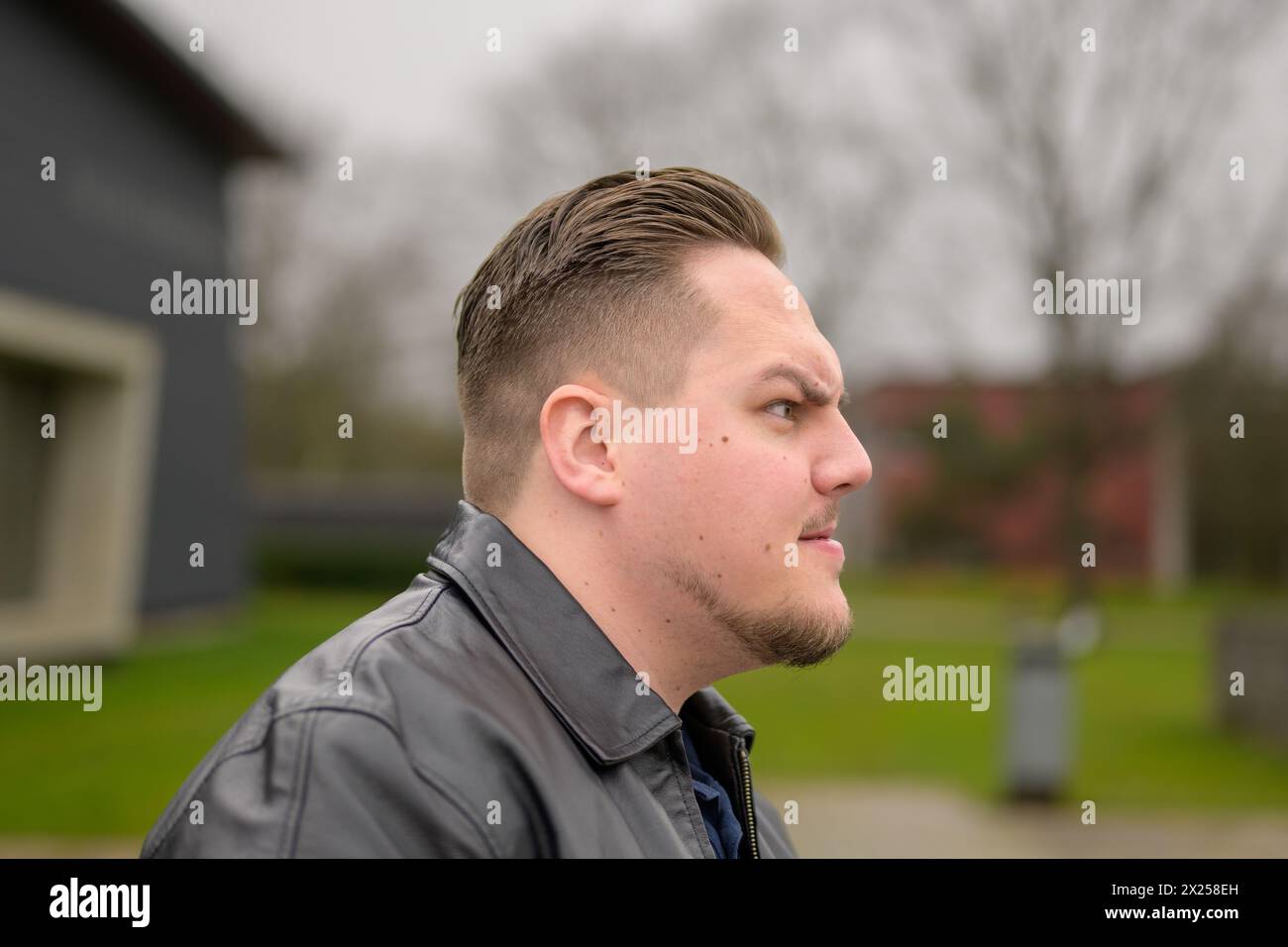 Side view of a young attractive man in his twenties looking to side with an angry emotion Stock Photo