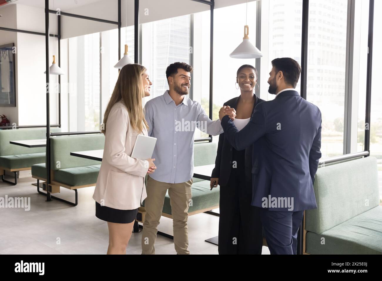 Positive diverse team of managers giving friends handshake Stock Photo