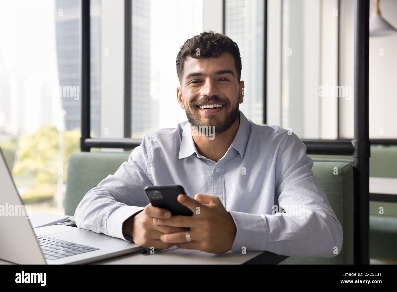 Happy young Arab freelancer man using gadgets for online work Stock Photo