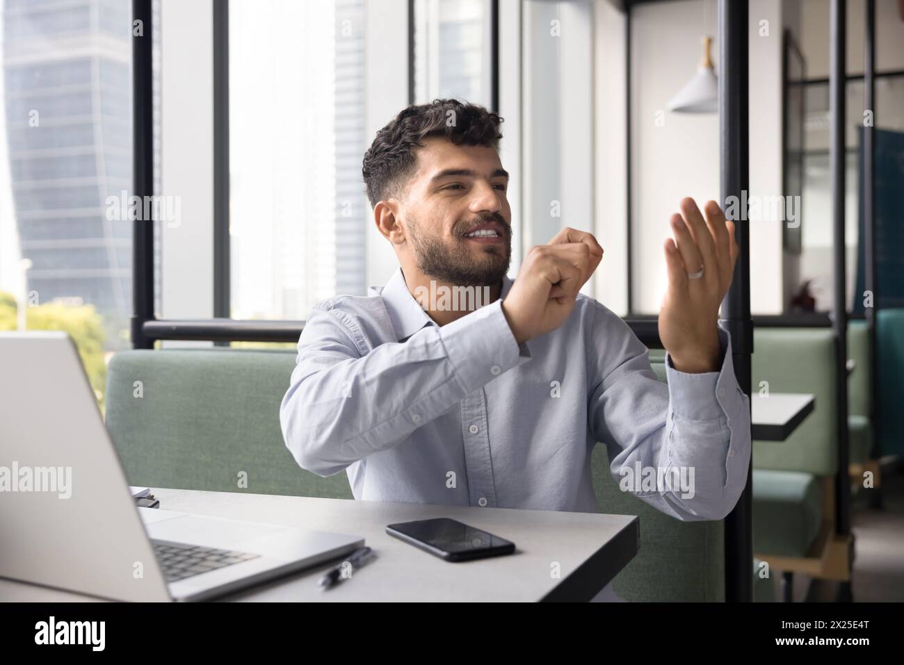 Positive young Arab businessman using invisible virtual interface Stock Photo