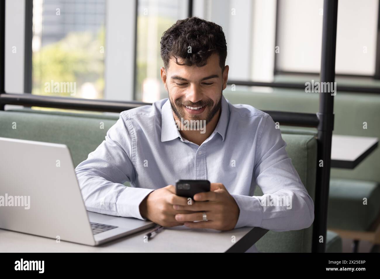 Happy successful young Arab freelance worker using digital gadgets Stock Photo