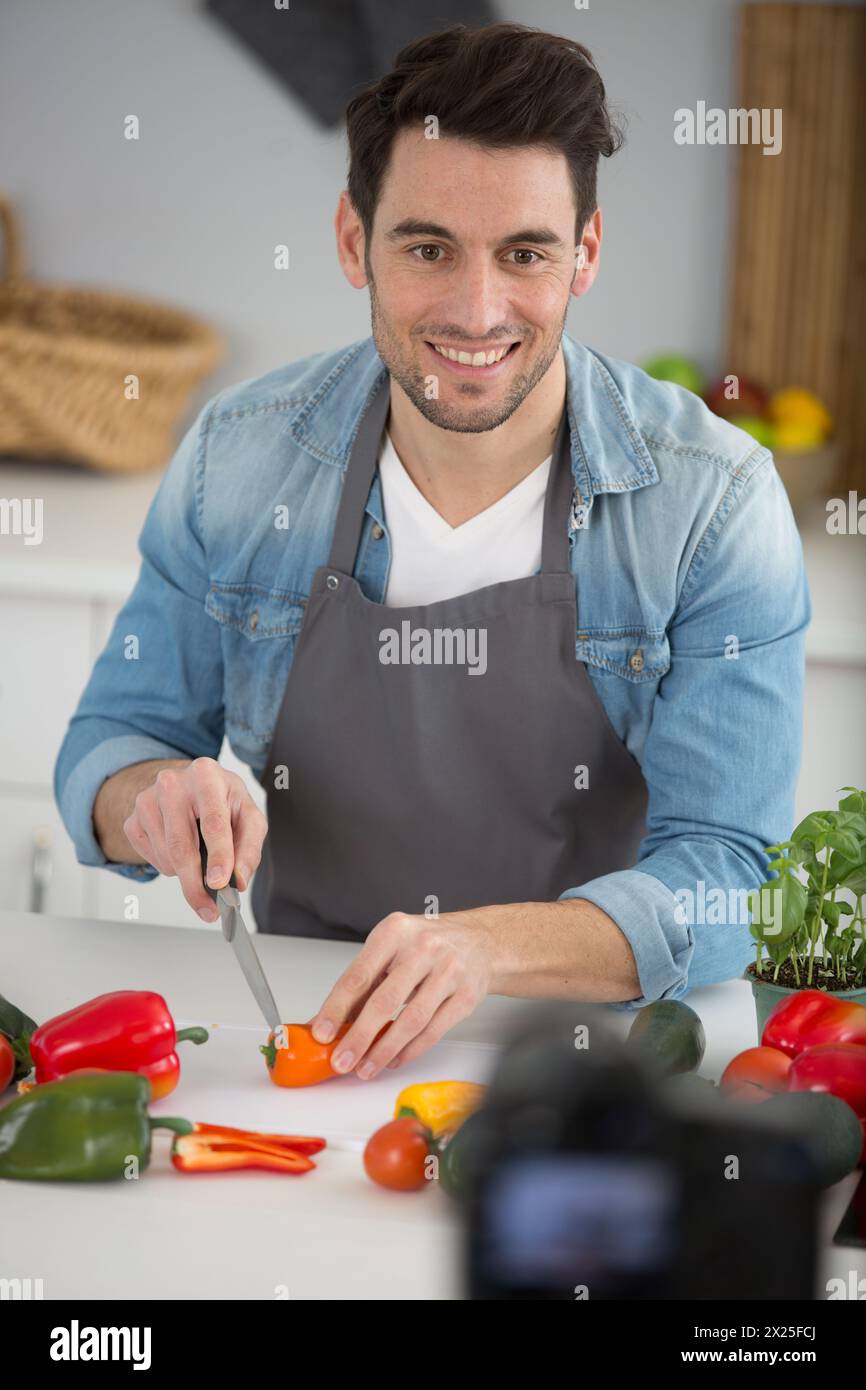 handsome food blogger recording video on camera in kitchen Stock Photo