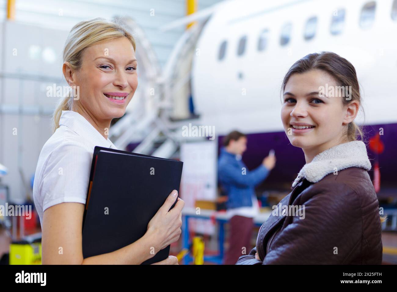 aero engineer and apprentice working in hangar Stock Photo