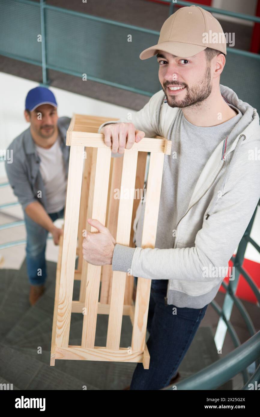 men carrying furniture up some stairs Stock Photo