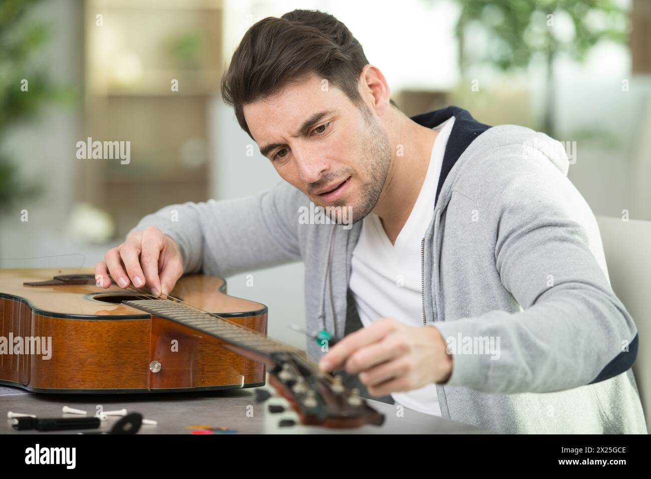 man fitting new string in his guitar Stock Photo - Alamy