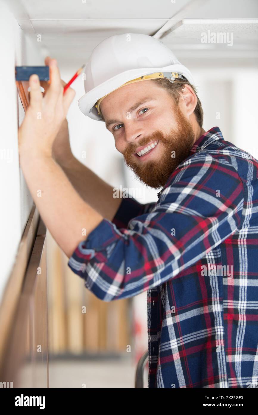 happy construction worker holding levelling tool Stock Photo - Alamy