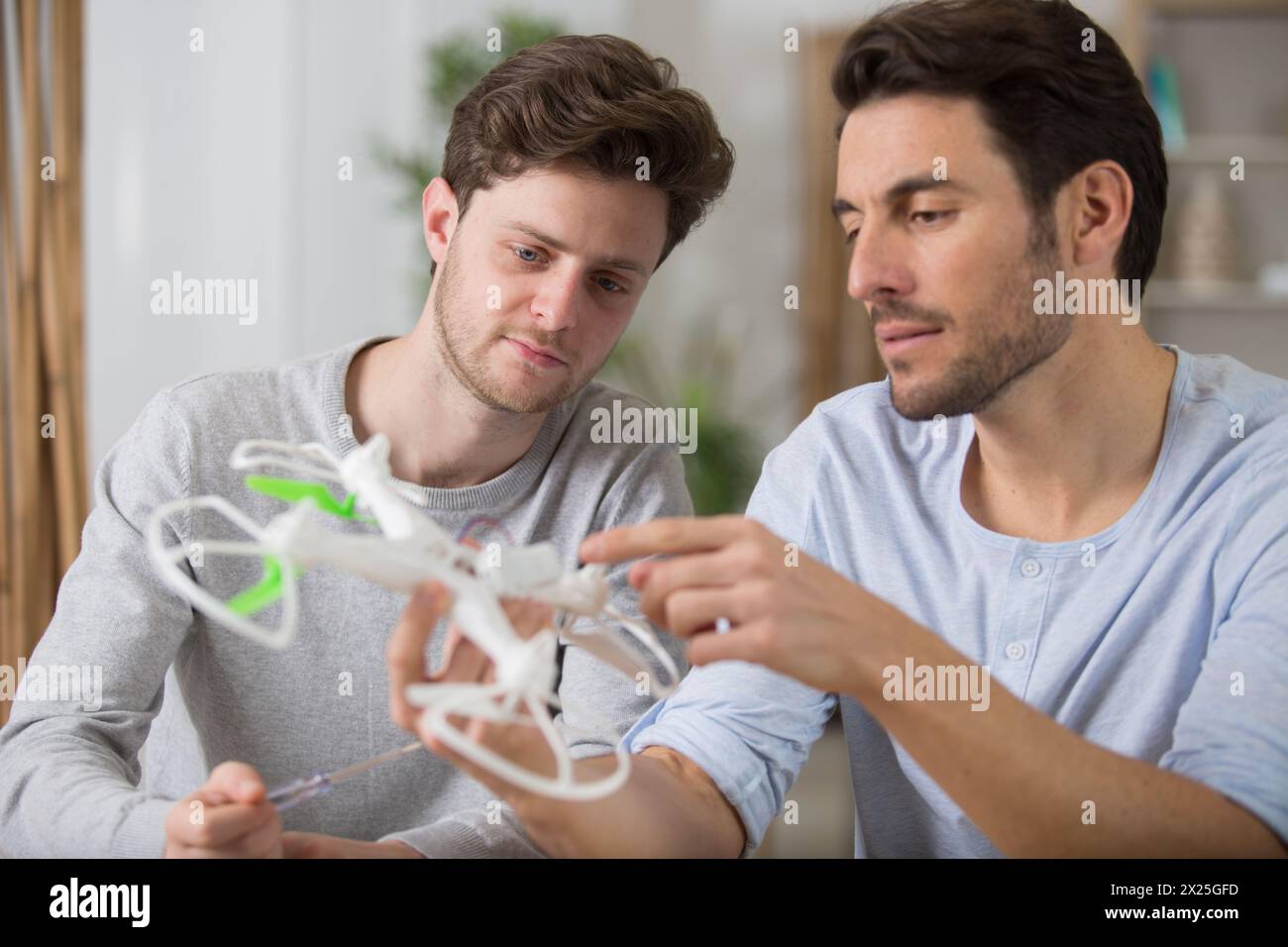 dad and son playing with toy drone Stock Photo - Alamy