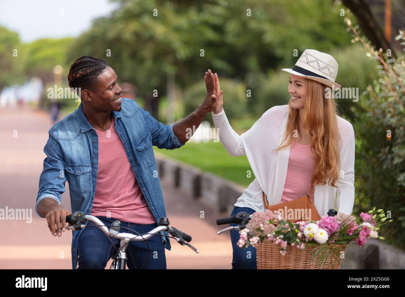 Mixed Riding portrait of a mixed race couple riding on bicycle Stock Photo - Alamy