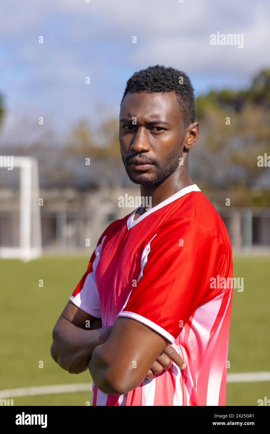 African American young male athlete standing on soccer field outdoors, looking serious, copy space Stock Photo