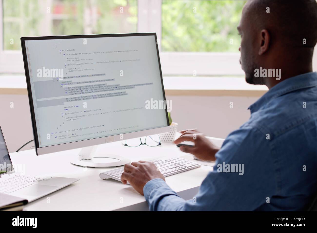 Programmer using laptop to write code in office Stock Photo