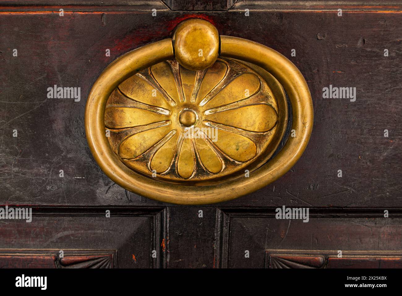 Historic brass door knob on a wooden door, background. Stock Photo