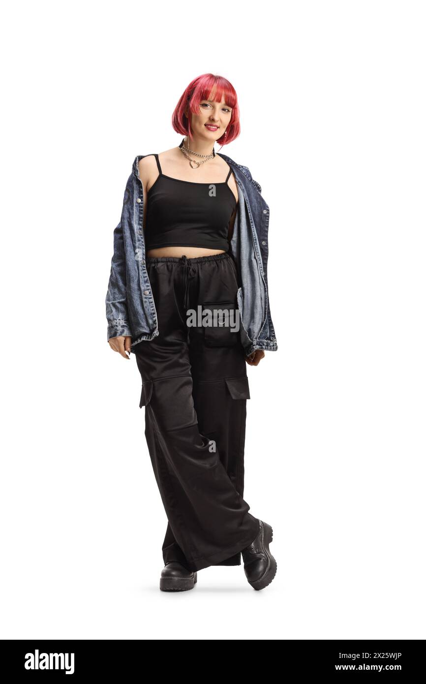 Young female with red heair wearing black wide trousers and jeans shirt off shoulders isolated on white background Stock Photo