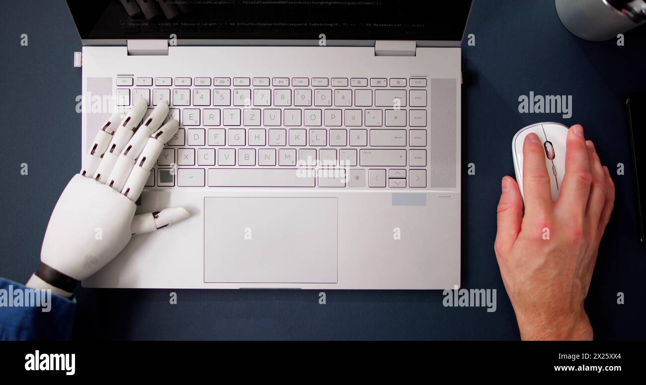 Man With Prosthetic Hand Working On Laptop. Artificial Limb Stock Photo