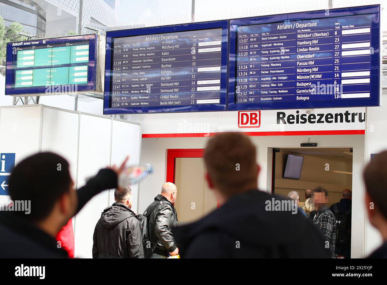 18.04.2024, München, Reisende Passagiere stehen vor einer Anzeigetafel am Reisezentrum und studieren den Fahrplan. Bayern Deutschland *** 18 04 2024, Munich, Passengers stand in front of a display board at the travel center and study the timetable Bavaria Germany Stock Photo