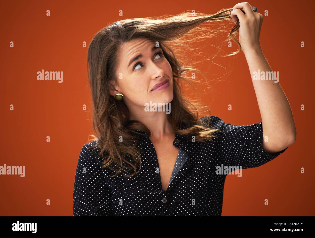 Studio, sad and woman with hair loss, confused and unhappy with hairdo, entangled and frustration. Red background, mockup space and worry for haircare Stock Photo