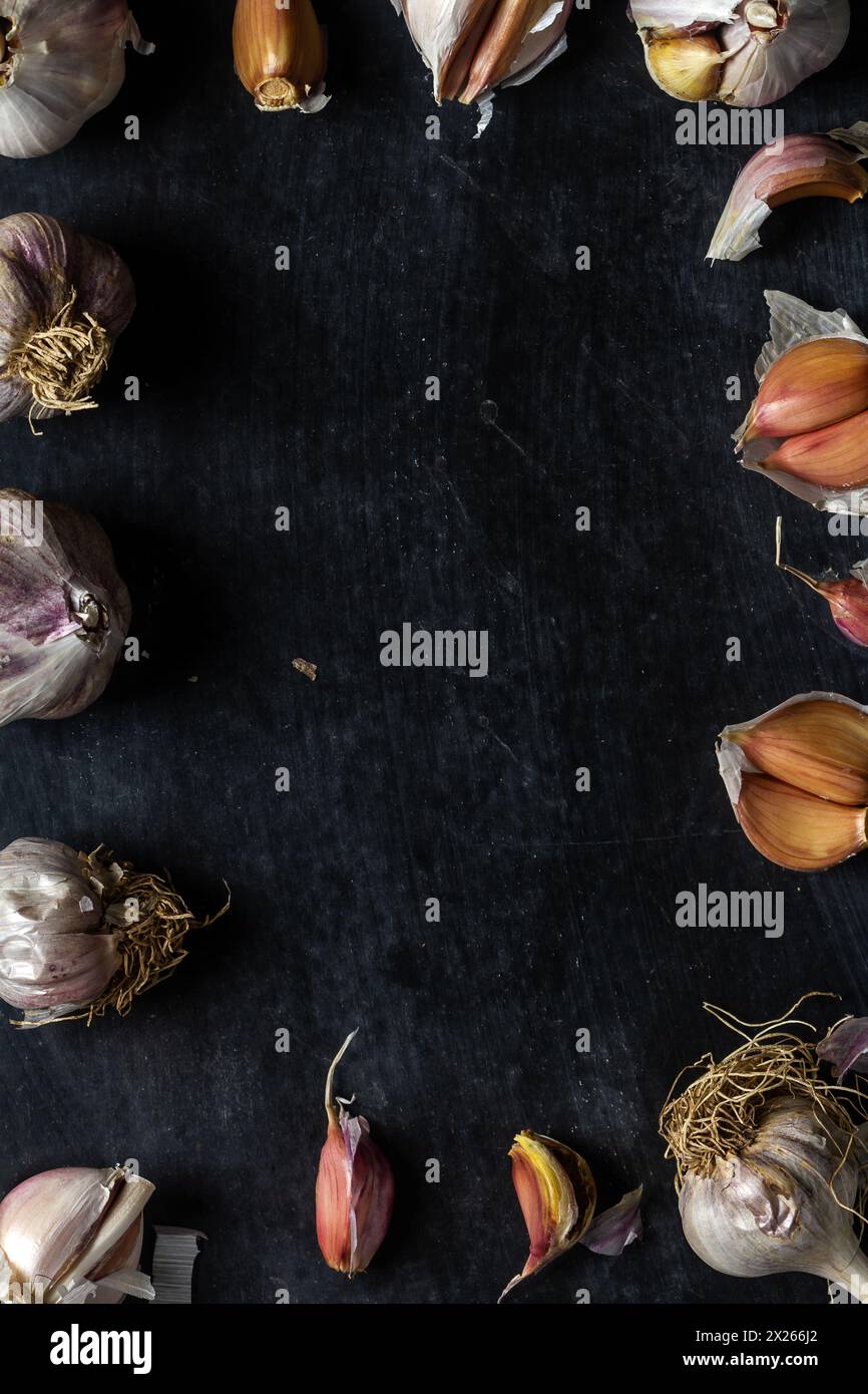 Fresh garlic bulbs and cloves grouped on black background. Flat lay ...