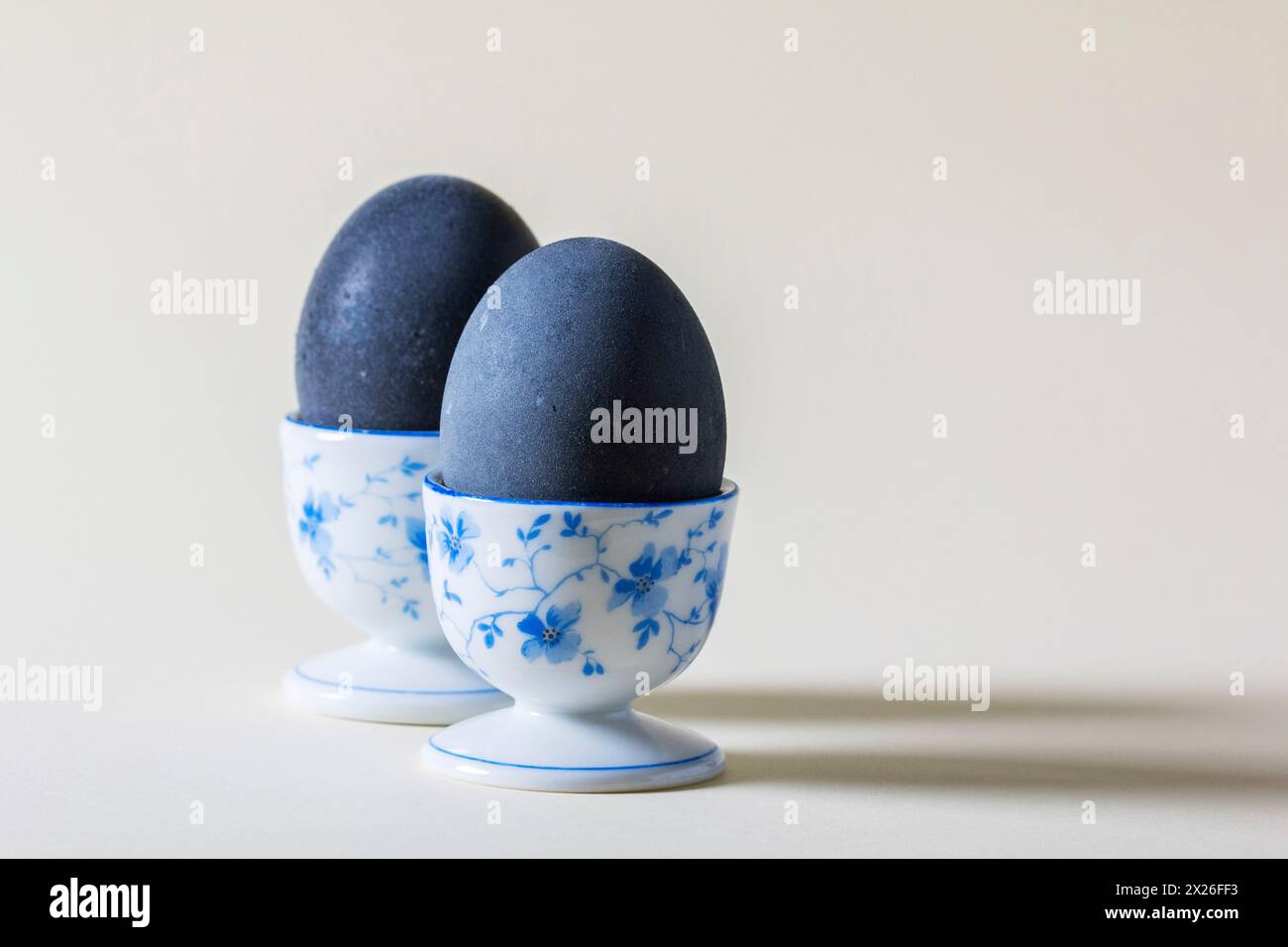 Eggs colored with wine in an egg cup on a light background. Easter concept. Stock Photo